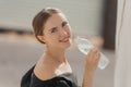 Close-up portrait of a beautiful young girl drinking water from the bottle. Street portrait. Royalty Free Stock Photo