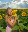 Close up portrait of a beautiful young girl in pink dress in a field of sunflowers Royalty Free Stock Photo