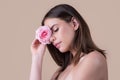 Close-up portrait of a beautiful young girl with a pink rose near face. Beautiful woman face and flower. Close-up Royalty Free Stock Photo