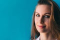 Close-up portrait of beautiful young happy woman on blue background, with space for slogan or text. Royalty Free Stock Photo