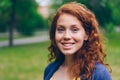 Close-up portrait of beautiful young lady smiling at camera in park in summer Royalty Free Stock Photo