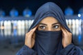 Close up portrait of beautiful young Muslim woman wearing Hijab looking away with Mosque at background during night Royalty Free Stock Photo