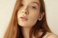 Close-up portrait of beautiful young red-haired girl posing isolated over grey studio background. Natural beauty Royalty Free Stock Photo