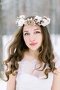 Close up portrait of a beautiful young woman, bride, with long curly hair and wreath from flowers and cotton on the head Royalty Free Stock Photo