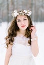 Close up portrait of a beautiful young woman, bride, with long curly hair and wreath from flowers and cotton on the head Royalty Free Stock Photo