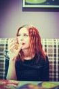 Close-up portrait of a beautiful young woman in the cafe with glass wine drinks it Royalty Free Stock Photo