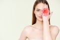 Close up portrait of beautiful young woman covering her eye with flower Royalty Free Stock Photo