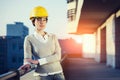 A beautiful young woman engineer is in front of a construction metal wall wearing protective gear, helmet and glasses. Royalty Free Stock Photo