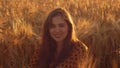 Close-up portrait of beautiful young woman in a field. Female face in the rays of sunset. Freedome and happiness concept