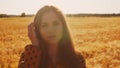 Close-up portrait of beautiful young woman in a field. Female face in the rays of sunset. Freedome and happiness concept