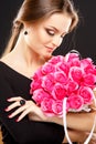 Close-up portrait of beautiful young woman with luxury jewelry and perfect make up holding bouquet Royalty Free Stock Photo