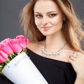 Close-up portrait of beautiful young woman with luxury jewelry and perfect make up holding bouquet Royalty Free Stock Photo