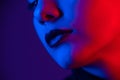 Close-up portrait of beautiful young woman with short hair in neon light. Girl with sensual lips in ultraviolet light. Royalty Free Stock Photo