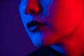 Close-up portrait of beautiful young woman with short hair in neon light. Girl with sensual lips in ultraviolet light. Royalty Free Stock Photo