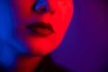 Close-up portrait of beautiful young woman with short hair in neon light. Girl with sensual lips in ultraviolet light. Royalty Free Stock Photo