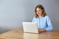 Close up portrait of a beautiful young woman smiling and looking at laptop screen Royalty Free Stock Photo