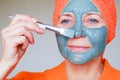 Cosmetic mask on the face. Close up portrait of beautiful young woman with towel on her head having skin care procedure. She is Royalty Free Stock Photo