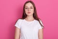 Close up portrait of beautiful young woman wearing spectacles and white casual outfit, feels happy, looks at camera, model posing Royalty Free Stock Photo