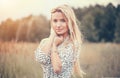 Close Up Portrait of beauty girl with fluttering white hair enjoying nature outdoors, on a field. Flying blonde hair on the wind