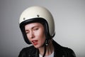 Close-up portrait of biker young woman, making funny face, wearing white helmet, with red lips. Studio background. Royalty Free Stock Photo