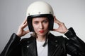 Close-up portrait of biker young woman, wearing white helmet, holding her head, red lips. Studio background. Royalty Free Stock Photo