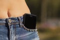 Close-up portrait of Black smartphone in front pocket of girl`s jeans Royalty Free Stock Photo