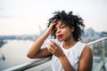 A close-up portrait of a woman standing on a terrace, drinking coffee. Royalty Free Stock Photo