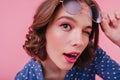 Close-up portrait of blithesome brown-eyed girl isolated on pink background. Studio shot of gorgeou