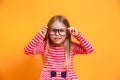 Close-up portrait of blond funny girl in red dress and glasses on yellow background Royalty Free Stock Photo