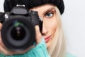 Close-up portrait of blonde girl photographer taking photo on DSLR camera. Royalty Free Stock Photo