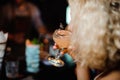 Close up portrait of blonde woman drinking alcoholic cocktail