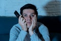 Close up portrait of bored sleepless young man on the couch watching TV and drinking beer at night Royalty Free Stock Photo