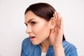 Close up portrait of brunette girl with cupped hand curiously li