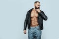 Close-up portrait of a brutal bearded man topless in a leather jacket