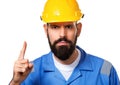 Close up portrait of bearded builder in hard hat, foreman or repairman in the helmet showing finger up, isolated