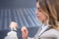 Close up portrait of business woman looking at her wrist digital watch, reading message, using app, standing outdoors in Royalty Free Stock Photo