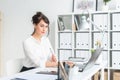 Close-up portrait of a businesswoman at her workplace working with pc, looking in camera, wearing office suit. Royalty Free Stock Photo