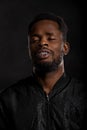 Close-up portrait of a buzzing relaxing African American man on a black background Royalty Free Stock Photo