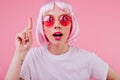 Close-up portrait of carefree young woman in pink periwig posing in casual t-shirt. Stunning lady i