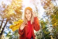 Close-up portrait of a caucasian attractive girl in an orange hat and red coat with a bouquet of yellow leaves Royalty Free Stock Photo