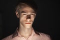 Close-up portrait of Caucasian attractive young man blinked his eyes. light shines from below. Standing Isolated on