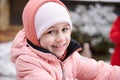 Close-up portrait of a Caucasian beautiful little child girl 6 years old, in pink warm winter clothes, smiling at camera Royalty Free Stock Photo