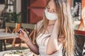 Close up portrait of a caucasian blonde girl sitting outside in a cafe holding a fork and eating her lunch Royalty Free Stock Photo