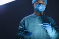 Close-up portrait of a caucasian doctor surgeon, in a sterile suit, mask, holding a scalpel in his hands, preparing to operate. On Royalty Free Stock Photo