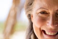 Close-up portrait of caucasian senior woman with brown eyes smiling and looking at camera Royalty Free Stock Photo