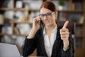 Close up portrait caucasian woman employee in glasses working in office talking on mobile phone