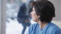 Close-up portrait of Caucasian woman using tablet and noticing masked robber behind glass door at background running