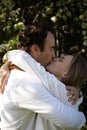 Close-up portrait of a Caucasian young loving couple kissing. Sunset scene. Flowering on background. Love and Royalty Free Stock Photo