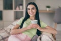 Close-up portrait of charming cheery calm long-haired girl sitting on cosy checkered cover drinking cacao at light