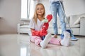 Cute little miss sitting on the white floor while holding spray for window Royalty Free Stock Photo